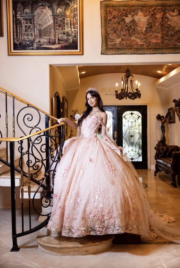Villas photoshoot in the grand staircase of Villa Toscana Miami with a quinceañera in a soft pink gown posing in a luxurious interior.