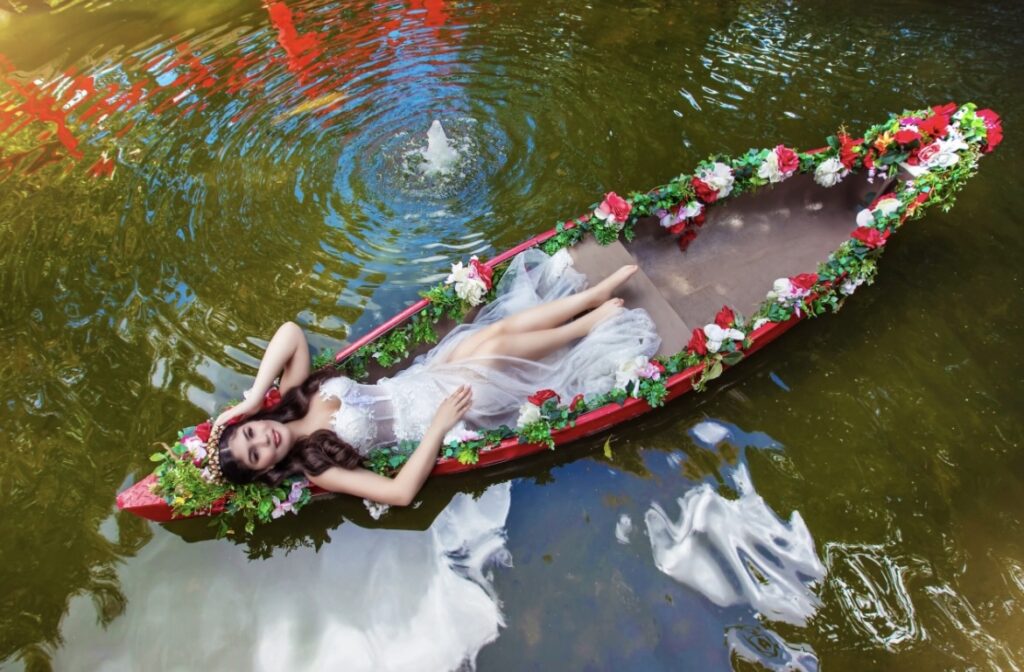 Villas photoshoot at Villa Toscana Miami with quinceañera in a floral boat on the lake, wearing a soft white dress surrounded by water reflections.