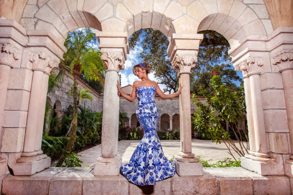 Castle quince photography at the Spanish Monastery: blue-and-white gown framed by triple stone arches in a palm courtyard.