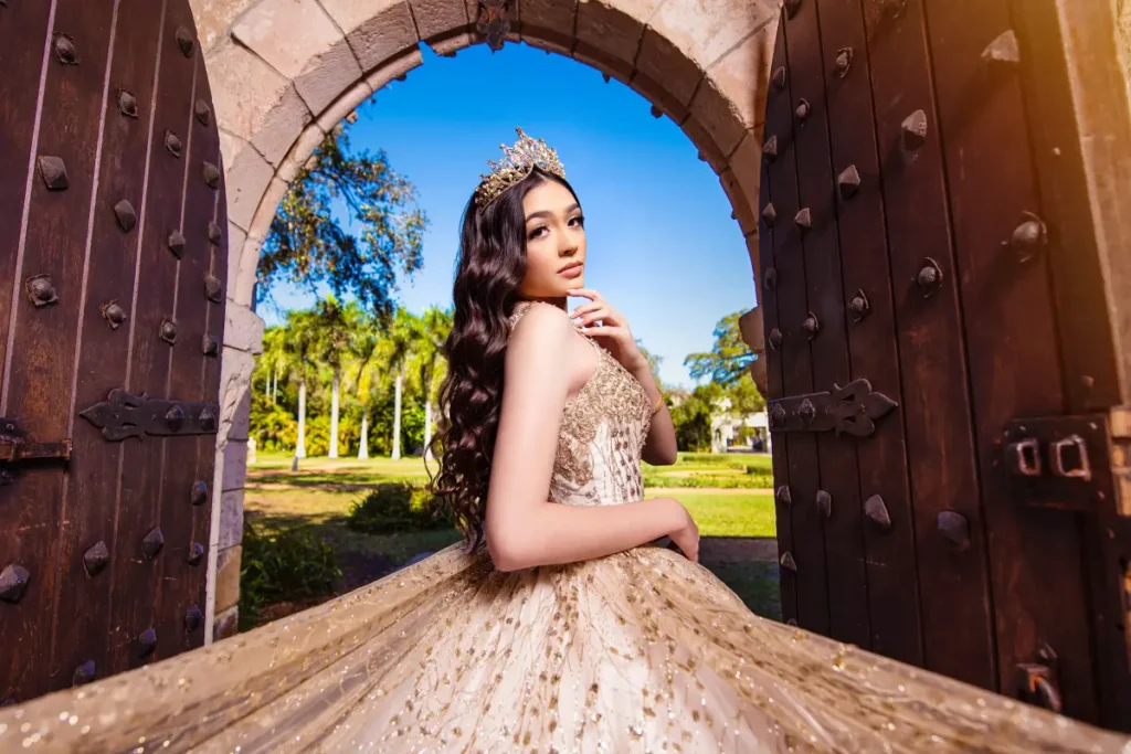 Castle quince photography at the Spanish Monastery: golden gown framed by stone arch and wooden doors, blue sky beyond.