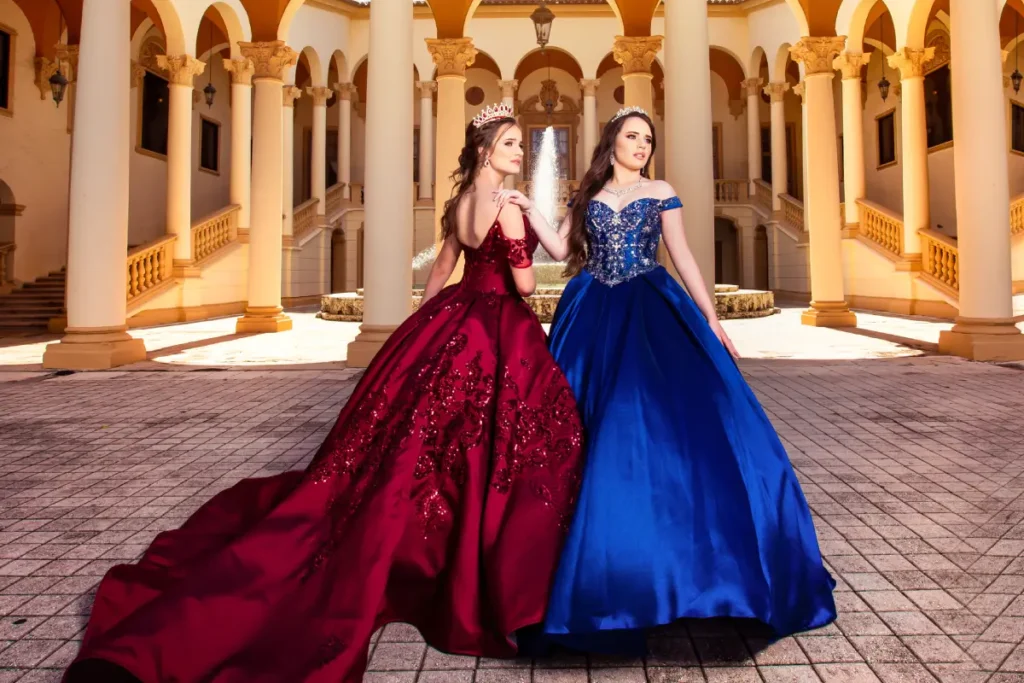 Castle quince photography at The Biltmore Hotel: red and blue gowns in a grand courtyard with arches and columns.