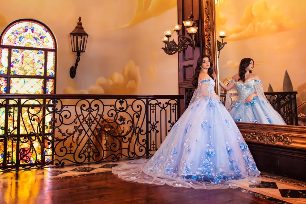 Castle quince photography at The Cruz Building: pastel blue gown reflected in mirror beside stained-glass window.
