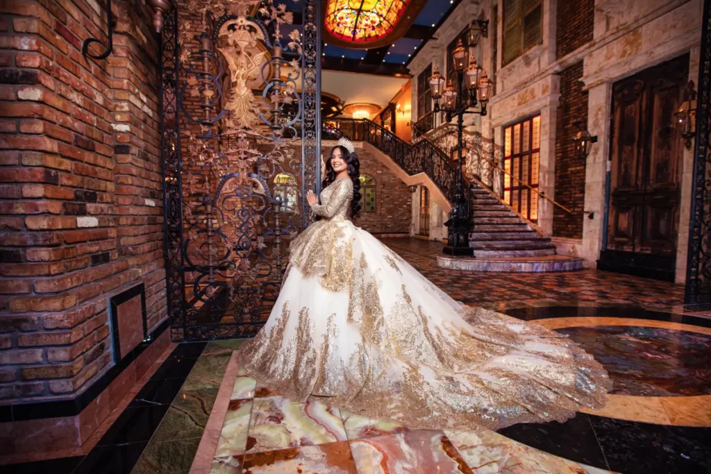 Castle quince photos at The Cruz Building: gold gown beside wrought iron gates, marble floors, and grand staircase.