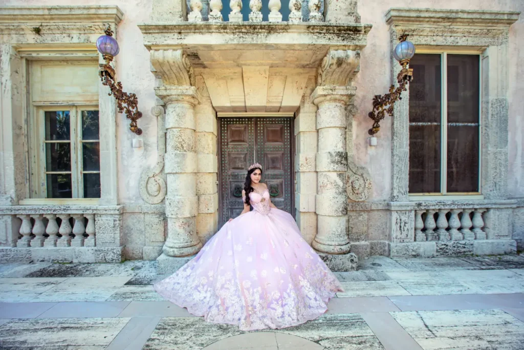 Castle quince photography at Vizcaya Museum: pink gown in front of ornate stone columns and vintage lanterns.