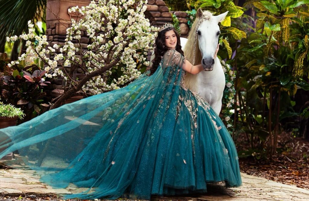 Royal quince photos with a white horse at Secret Gardens Miami, featuring an emerald gown and elegant nature scenery.